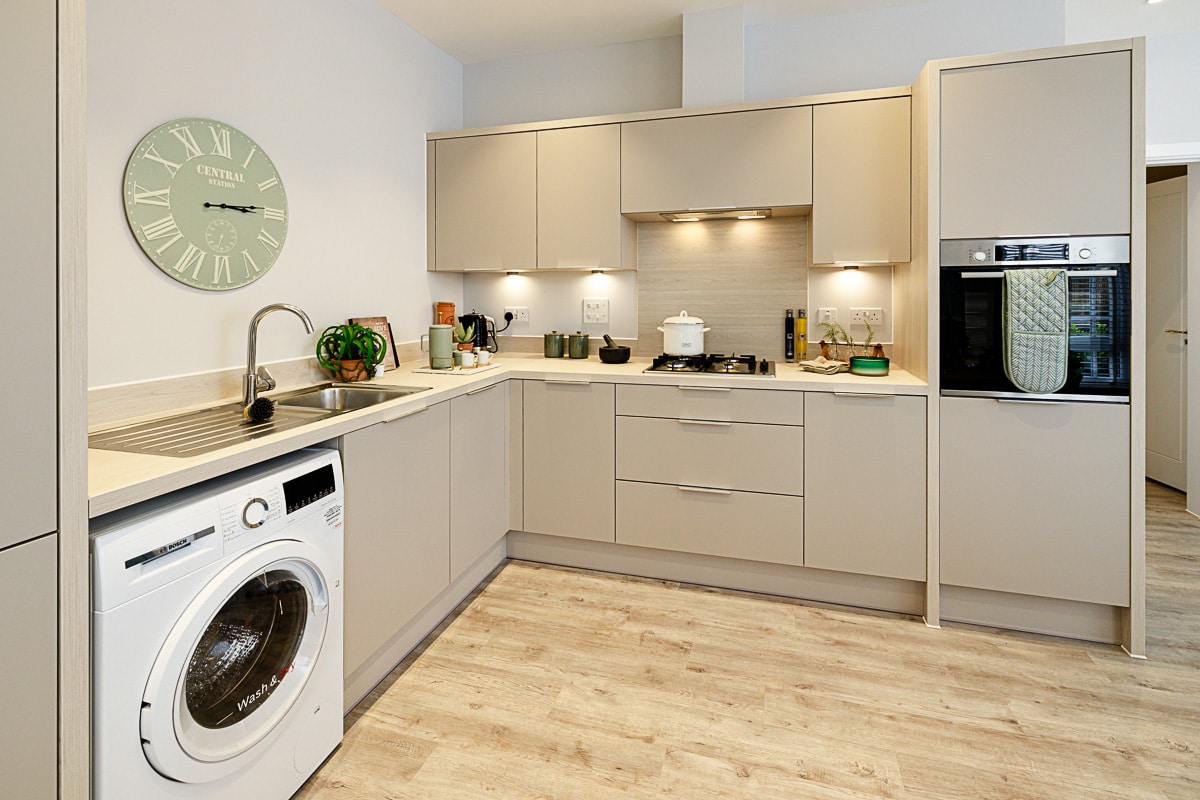 A kitchen space at Terlingham Gardens showing an integrated washing machine and oven.