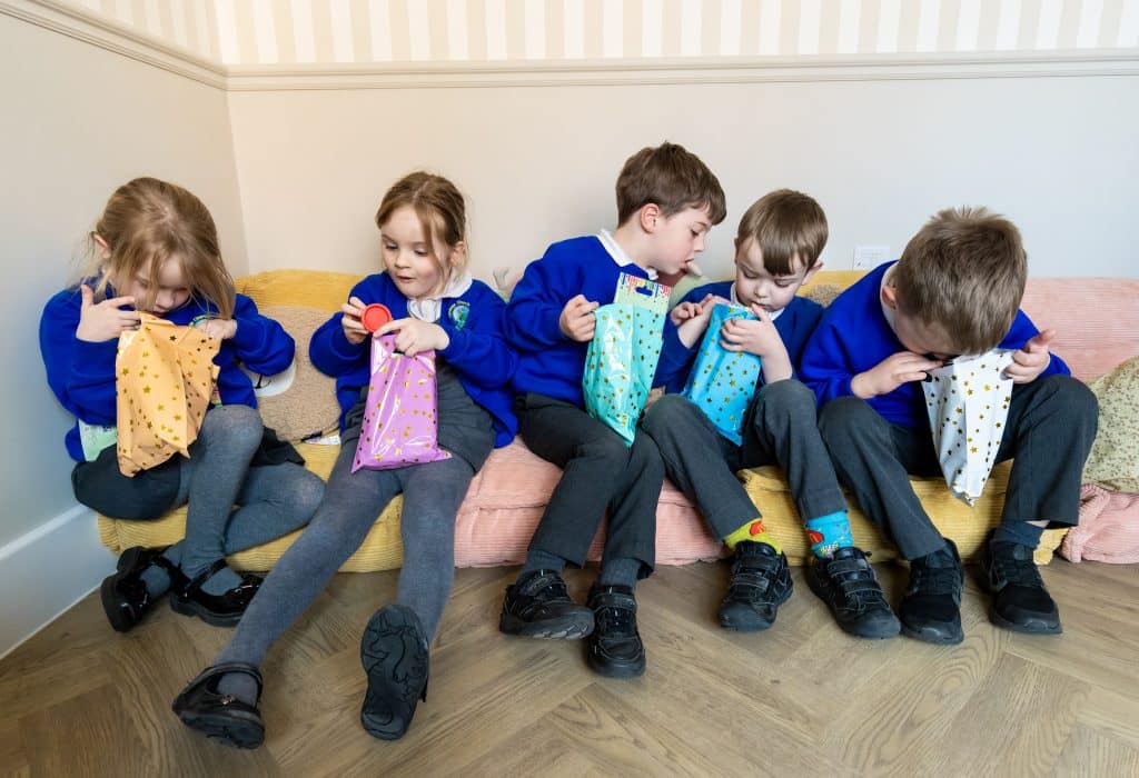 Lyminge school children opening goody bags.