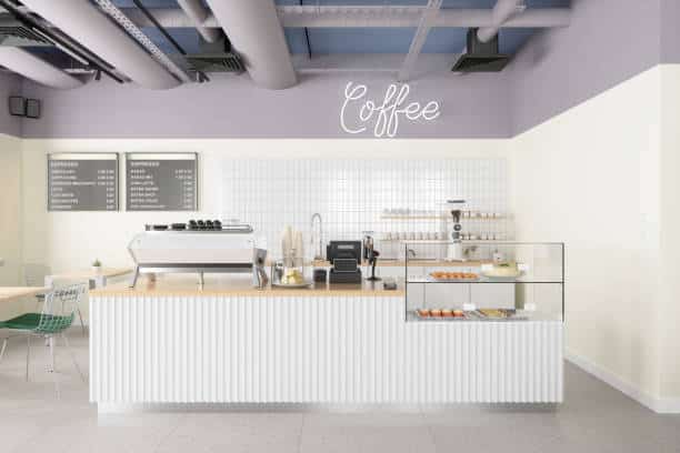 An empty coffee shop showing the menu on the wall and the counter with food available.